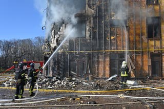 Ukrainian rescuers work to extinguish a fire in a damaged residential building following a drone attack in Kharkiv on 2 April 2026